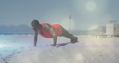 Image of spots over african american man exercising at beach