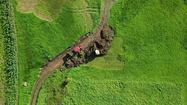 Aerial View Of Excavator Digging Soil On Field In Zas, A Coruna, Spain. topdown shot