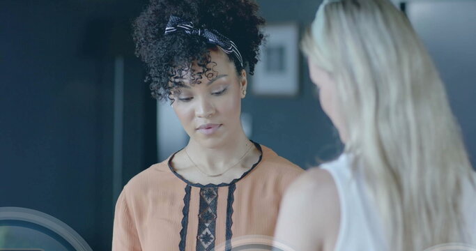 Image of padlock icons data processing over diverse businesswomen in office - Powered by Adobe