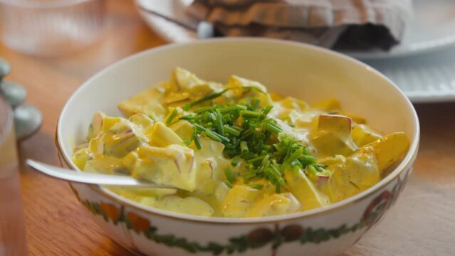 Creamy curry salad garnished with chives in a bowl at Scandinavian julefrokost
