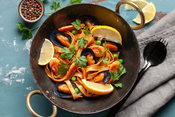 Tagliatelle pasta with mussels and shrimp in the bowl on the table. Mediterranean sea food cuisine