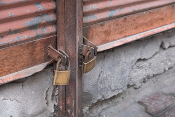 closed shop shutter. dirty, rusty and dusty padlocks. economic crisis and bankruptcies.