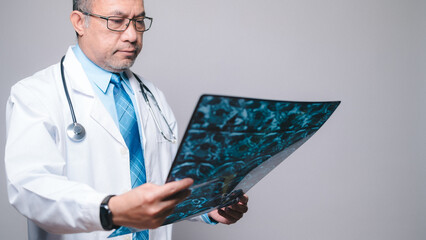 Doctor, lab concept. Professional doctor, holding and scrutinizing an X-ray film, works diligently...