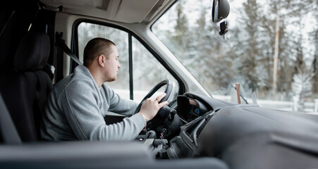 young charismatic male truck driver driving a car.