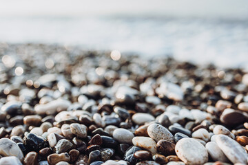 background of pebbles on the sea. Mediterranean coastal area. small sea stones. pebbles close up. photo of stones with bokeh effect