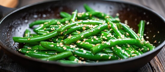 Green beans and sesame seeds cooked in a frying pan. - obrazy, fototapety, plakaty