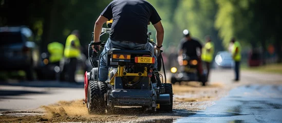 Fototapeten rear view Road workers use a hot melt machine to paint dividing lines on the road surface © GoDress