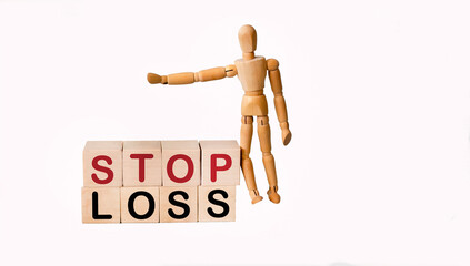 Stop loss written on wooden blocks on a white background with a wooden doll