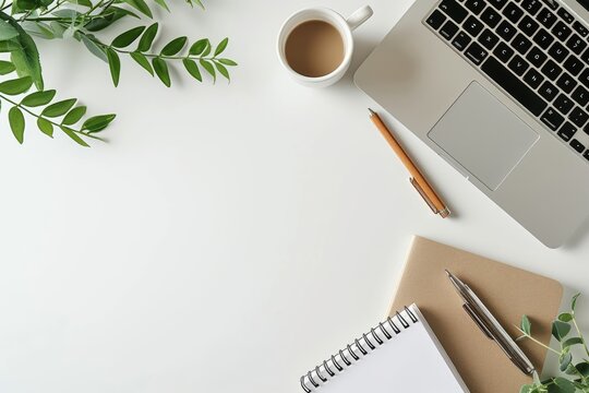 Modern workspace with laptop, notepad, coffee, and greenery on white background. Ideal for business and creativity concepts.