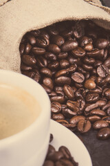 Coffee in cup and roasted dark coffee beans in bag