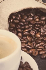Coffee in cup and roasted dark coffee beans in bag