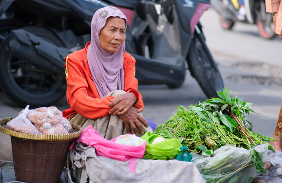 Ol Indonesian woman selling vegetables at traditional market of Yogyakarta, 25 January 2024