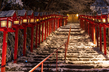 Kifune shrine stone stairs and traditional light pole in snowy winter night, Kyoto, Japan.