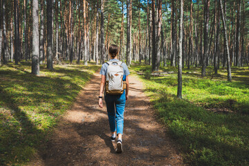 Young woman with backpack hiking in the forest. Hiking concept. - 721084019