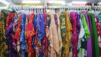 Various colored textile hang on rack in the store for sale, colorfull background