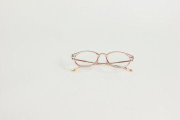 Pastel pink glasses on white background