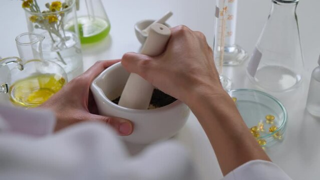 The pharmacist is making natural or herbal medicine as the homeopathy remedy in the laboratory for a professional supplement and vitamin product. 