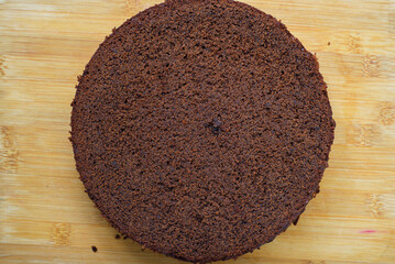 Plain chocolate cake on a wooden table. Chocolate sponge cake texture.