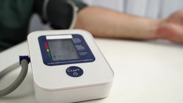 the girl measures blood pressure with a tonometer