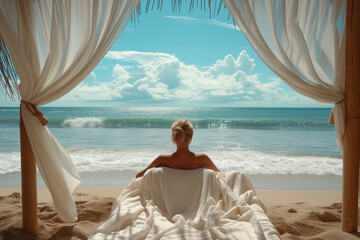 Woman sitting and relaxing on a bed by the sea