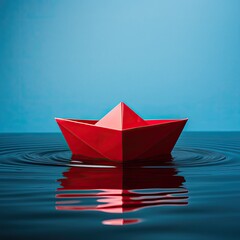red paper boat sailing on water causing waves and ripples