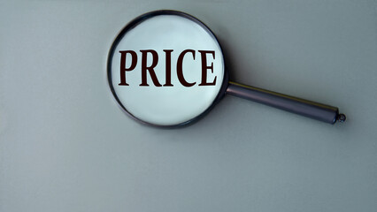 PRICE - word on grey background with magnifying glass close-up