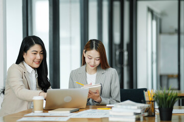 Obraz premium Two business women are discussing the work they have done together and exchanging ideas. To work to develop the business better.
