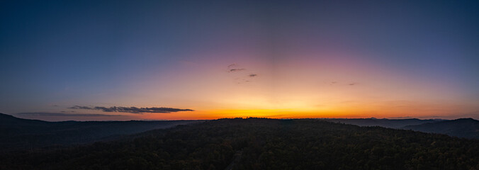 Aerial panorama view  A breathtaking sunset paints the sky with vibrant hues of orange and red,...