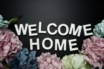 Welcome Home alphabet letter with flower decoration on black background