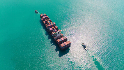 Aerial side view of cargo ship carrying container and running for export goods from cargo yard port...