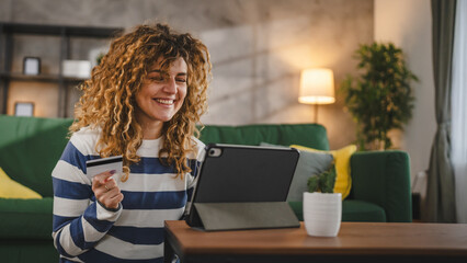 young woman caucasian female hold credit card online shopping at home