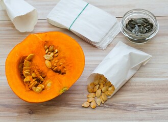 Getting own seeds from  pumpkins. Dried seeds of hokaido pumpkin in paper bag, green seeds from oil...