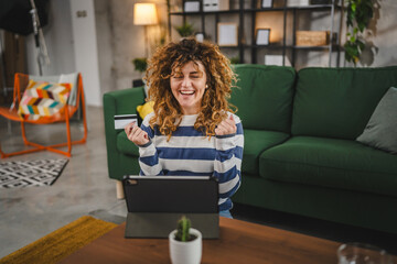 young woman caucasian female hold credit card online shopping at home