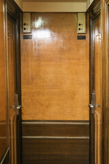 Wooden paneled cabin corridor hallway aisle to staterooms and suites onboard legendary ocean liner...
