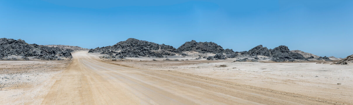 gravel road and basalt buttes near desert shore, south of Luderitz,  Namibia