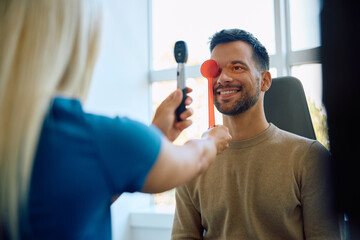 Happy man during routine eye exam at ophthalmologist's.