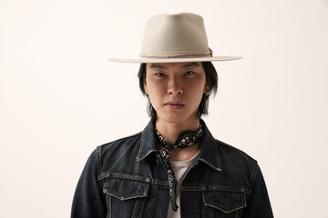 Fashionable Asian young man wearing hat posing over white background. Mock-up.
