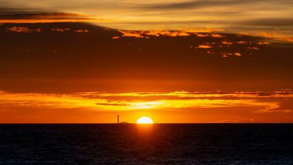 Obraz premium Phare à l'horizon au coucher du soleil