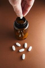 Białe tabletki rozsypane luzem z butelki z lekami