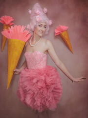 Fashion shot of beautiful young woman in pink dress with ice cream cone. Sweet lady cosplay.