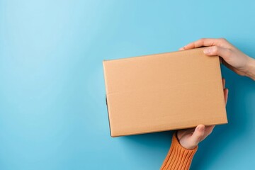 Top view to female hand holding brown cardboard box on light blue background. Mockup parcel box. Packaging, shopping, delivery concept, Generative AI