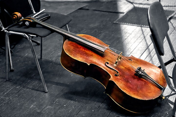 a string musical instrument of a symphony orchestra the cello lies on the theater stage