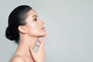 Face lift and Anti Aging Treatment. Beautiful Face of Spa Woman with White Lifting Arrows. Youth...