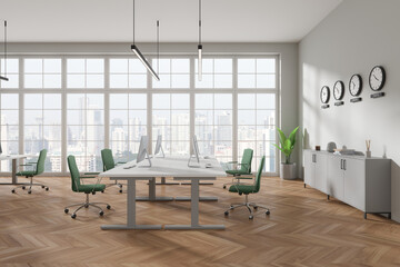 Cozy coworking interior with pc desktop, world clock and panoramic window