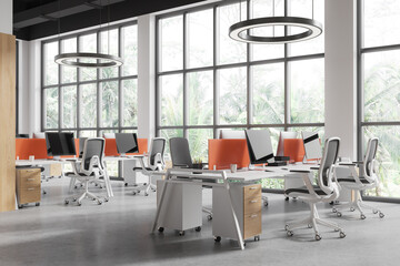Modern office coworking interior with pc monitors and chairs in row, window
