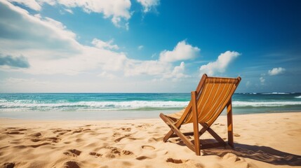 Beach chair on a tropical beach on a bright summer day. Summer vacation concept. Deck chair standing on a sandy coast. Sand beach with a chair composition. Travel and holidays.