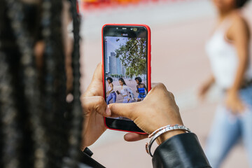 Mobile screen while women recording a video dancing in the street