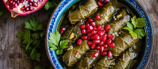 Lebanese stuffed grape leaves with pomegranate seeds, viewed from above, are a traditional Middle Eastern dish.