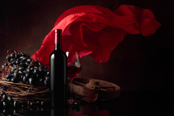 Red wine with grapes on a background of red flutters curtain.