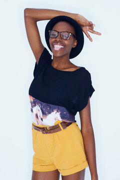 Fashion, peace sign and black woman on a white background in trendy, stylish and casual clothes. Hand emoji, hipster style and isolated person with tongue out, glasses and cool accessory in studio